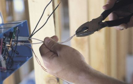 A person is cutting a wire with a pair of pliers.