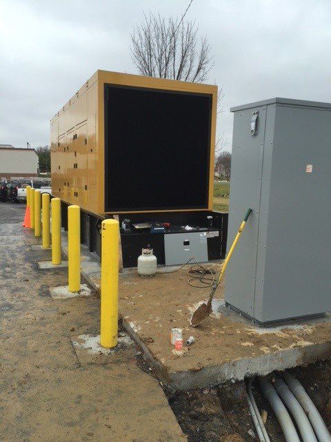 A yellow truck is parked next to a gray box
