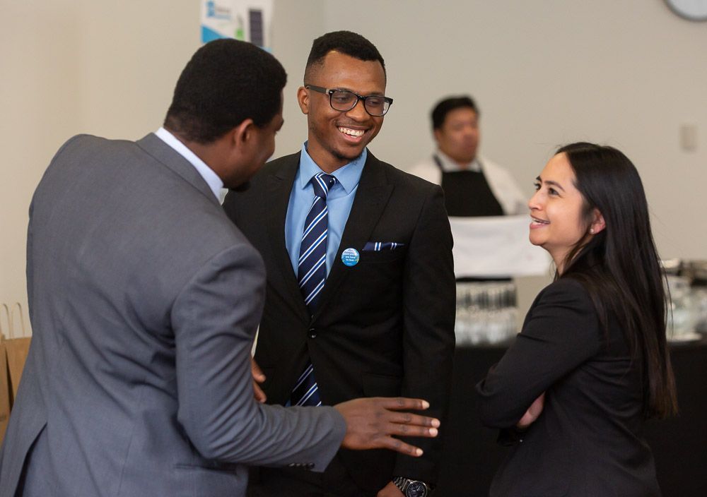 A group of people in suits and ties are talking to each other.
