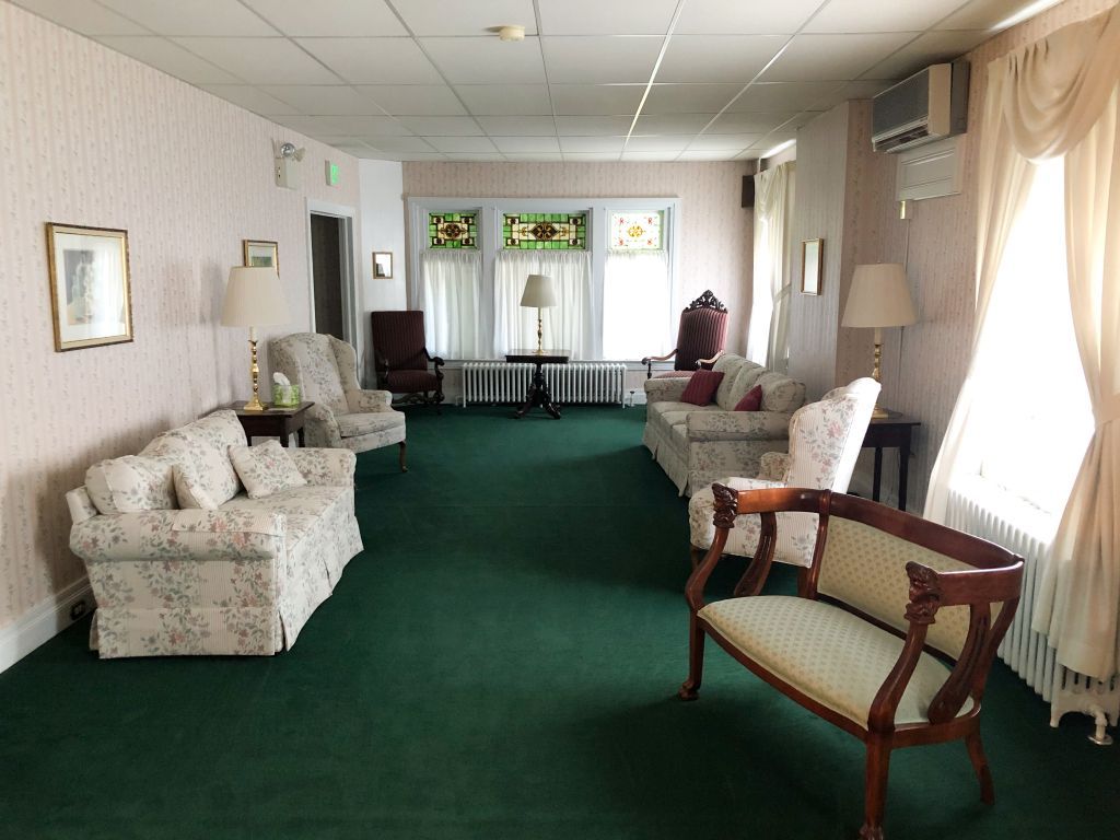 A living room with a lot of furniture and a green carpet.