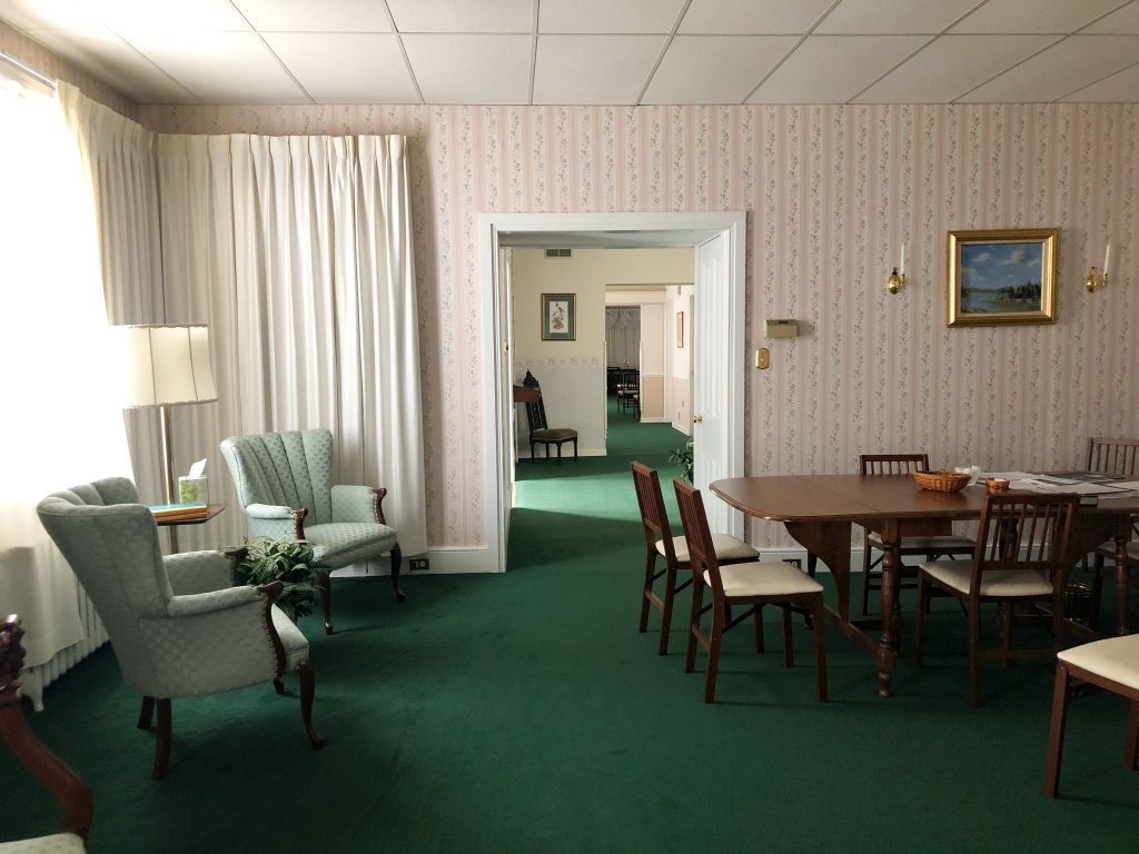 A living room with a table and chairs in it.