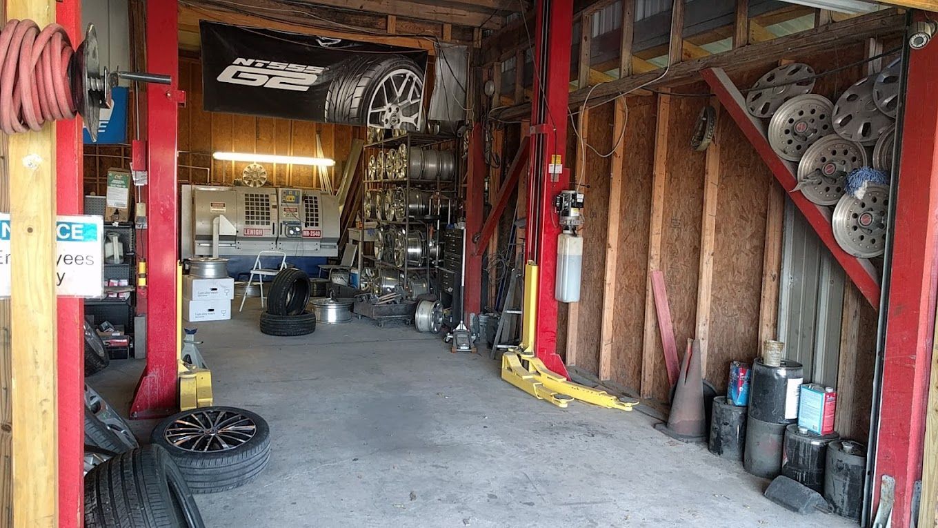 A garage filled with lots of tires , wheels , and tools.