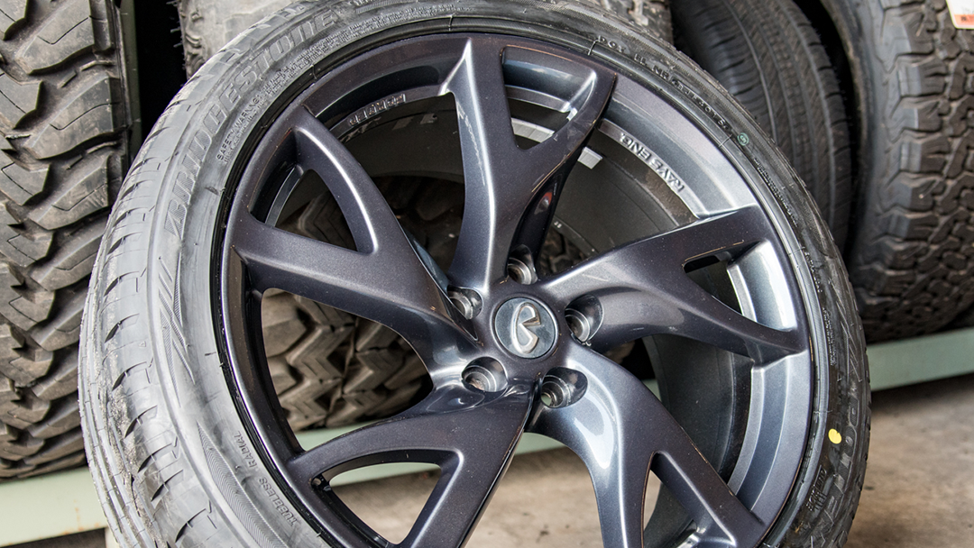 A close up of a car wheel with a tire in the background.