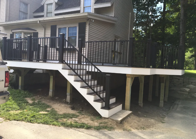 A house with a deck and stairs on the side of it.