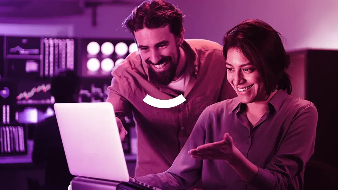 A man and a woman are looking at a laptop computer.