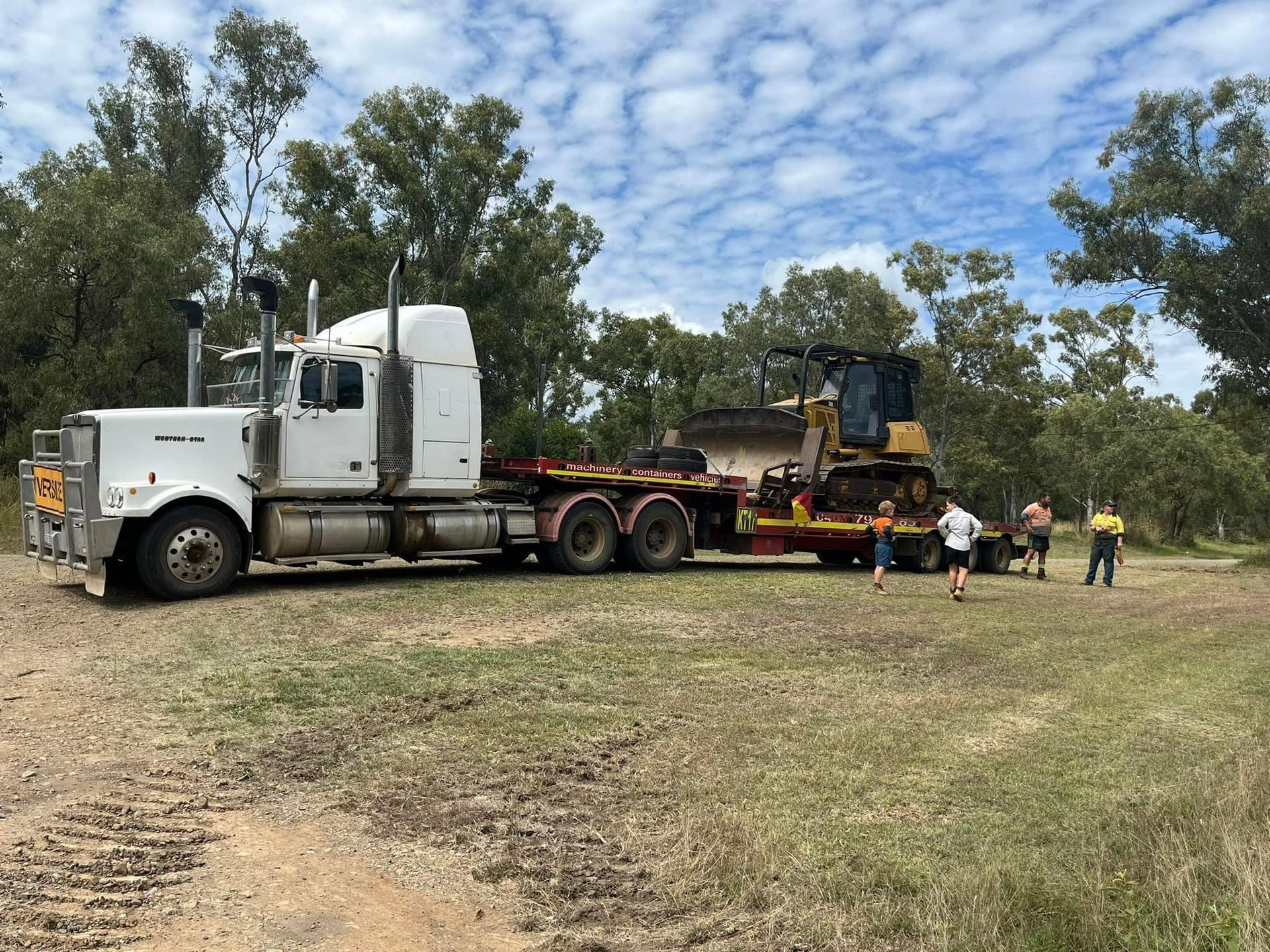 White Semi-truck Hauling Heavy Equipment — K & T Daley in Gracemere, QLD White Semi-truck Hauling Heavy Equipment — K & T Daley in Gracemere, QLD