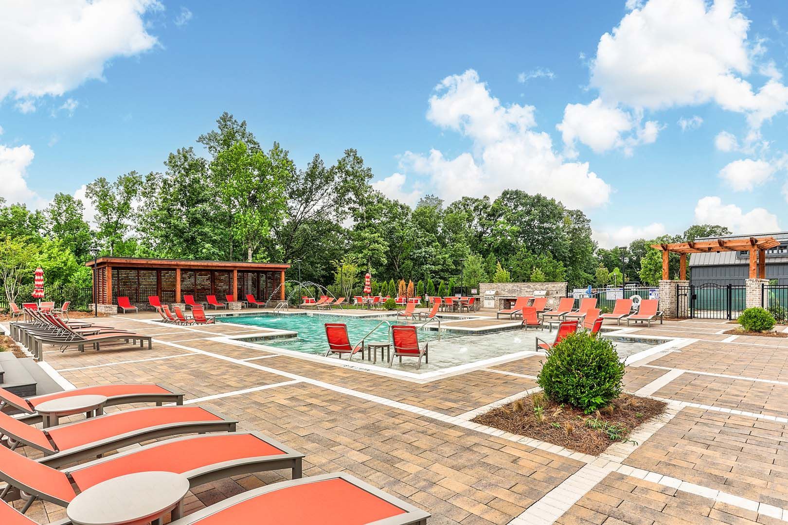 A large swimming pool surrounded by chairs and tables.