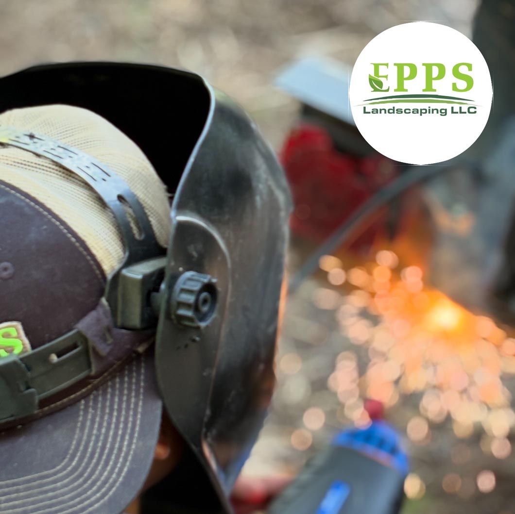Landscaper welding metal, with orange sparks and EPPS Landscaping logo in the corner