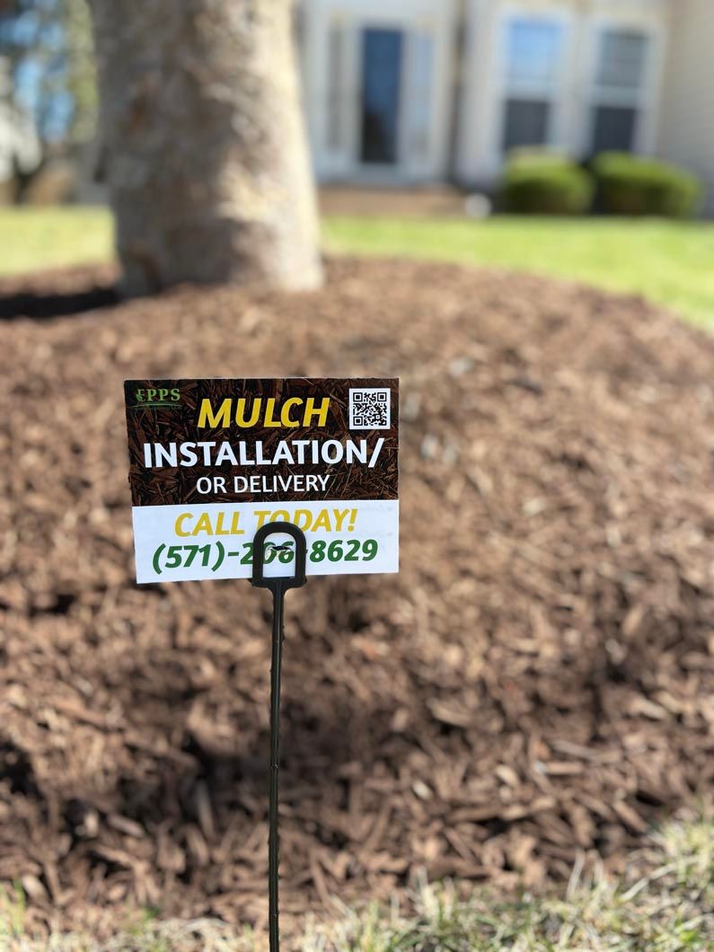 Mulch installation lawn sign on a freshly mulched yard with a tree and house in the background