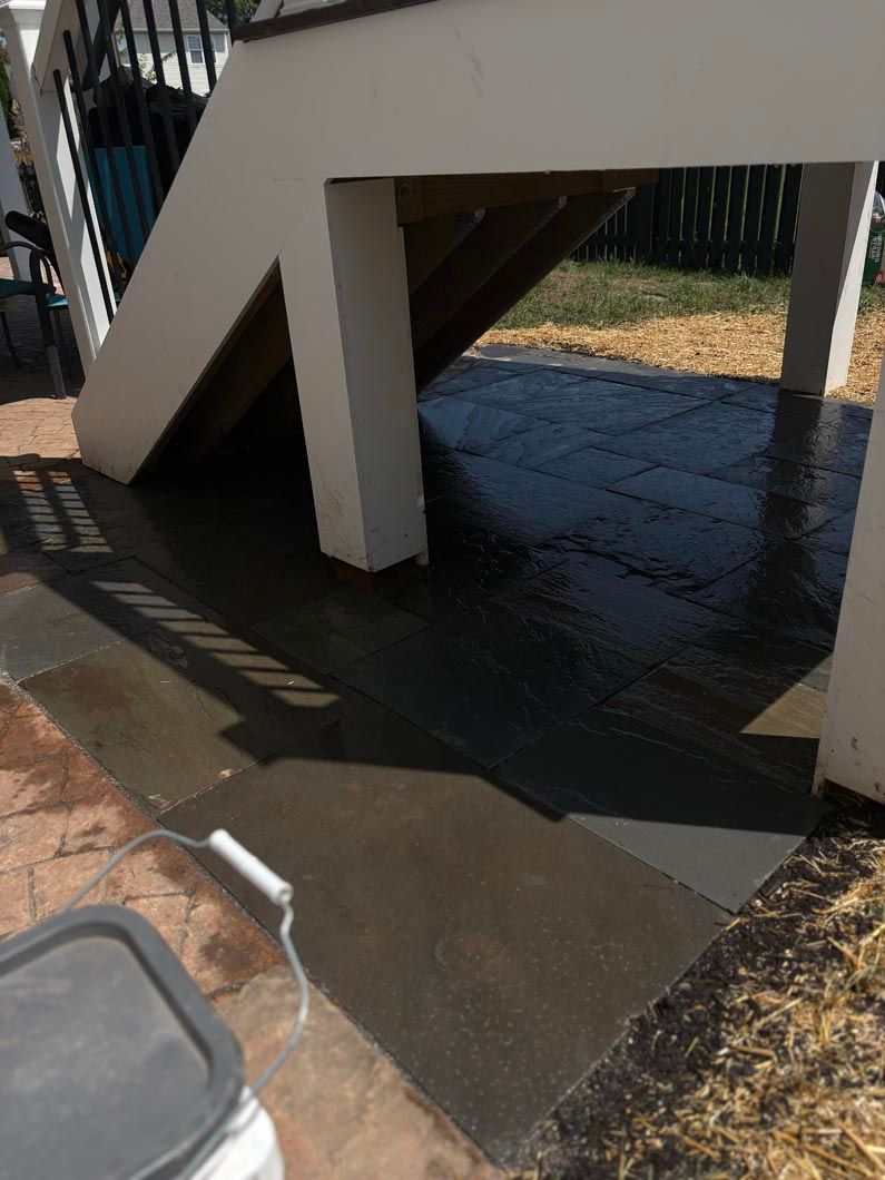 Under-stairs access blocked by a deep puddle of water on a sidewalk.