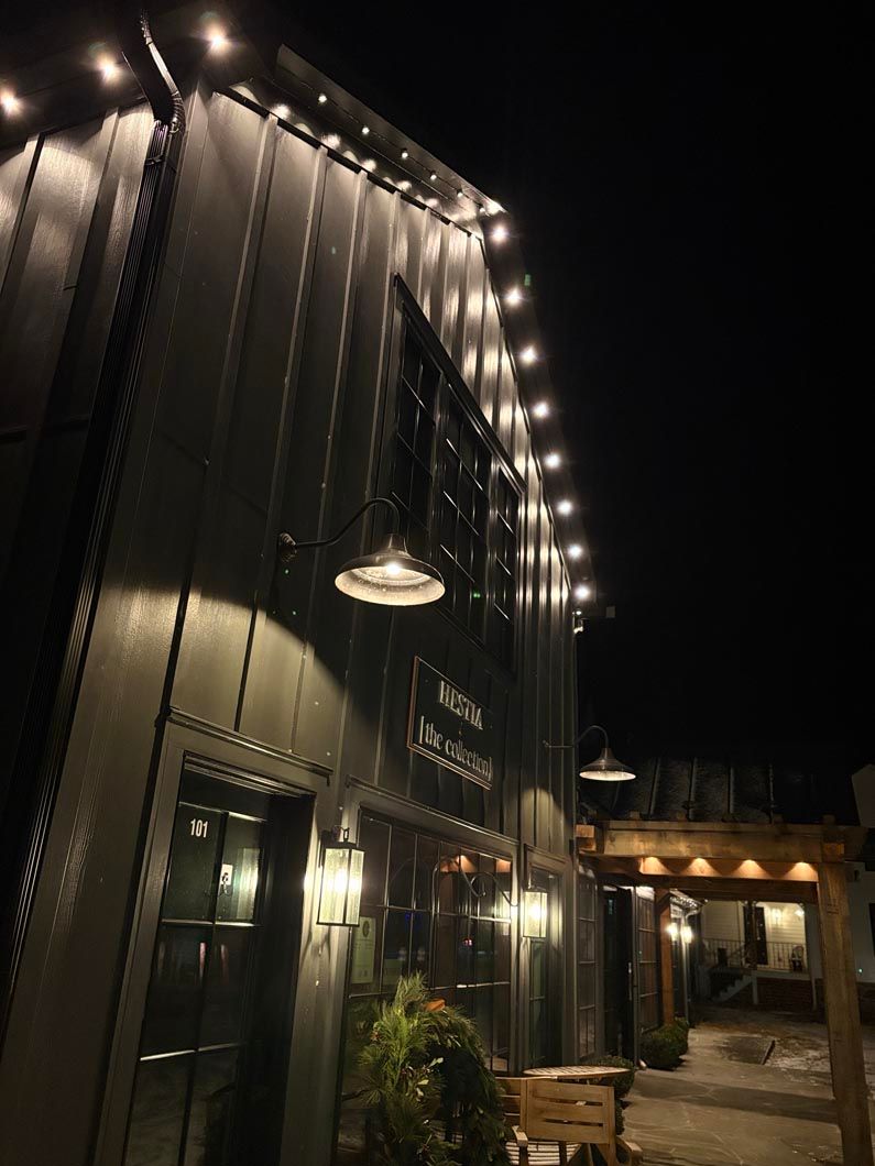 String-lit building exterior at night with arched walkway and hanging lamps
