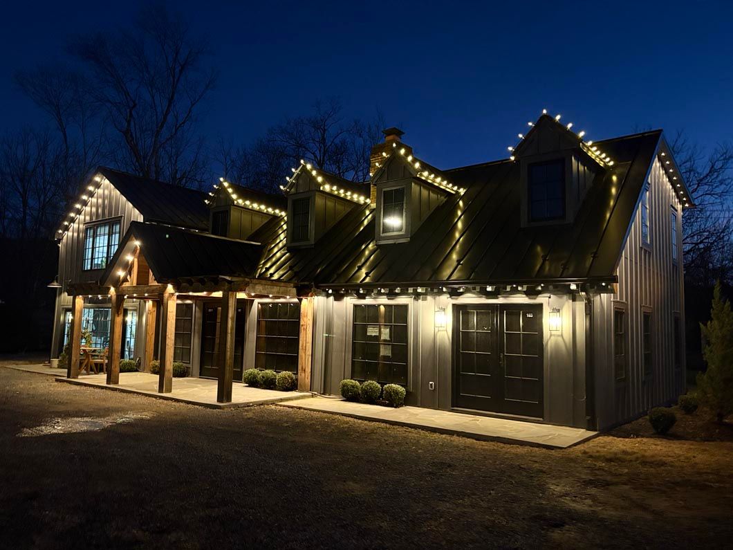 Snowy lodge entrance lit by warm string lights at dusk
