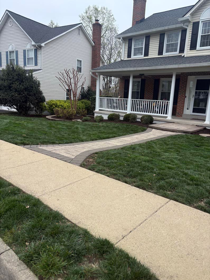 Suburban houses with a curved concrete walkway and neatly trimmed lawn