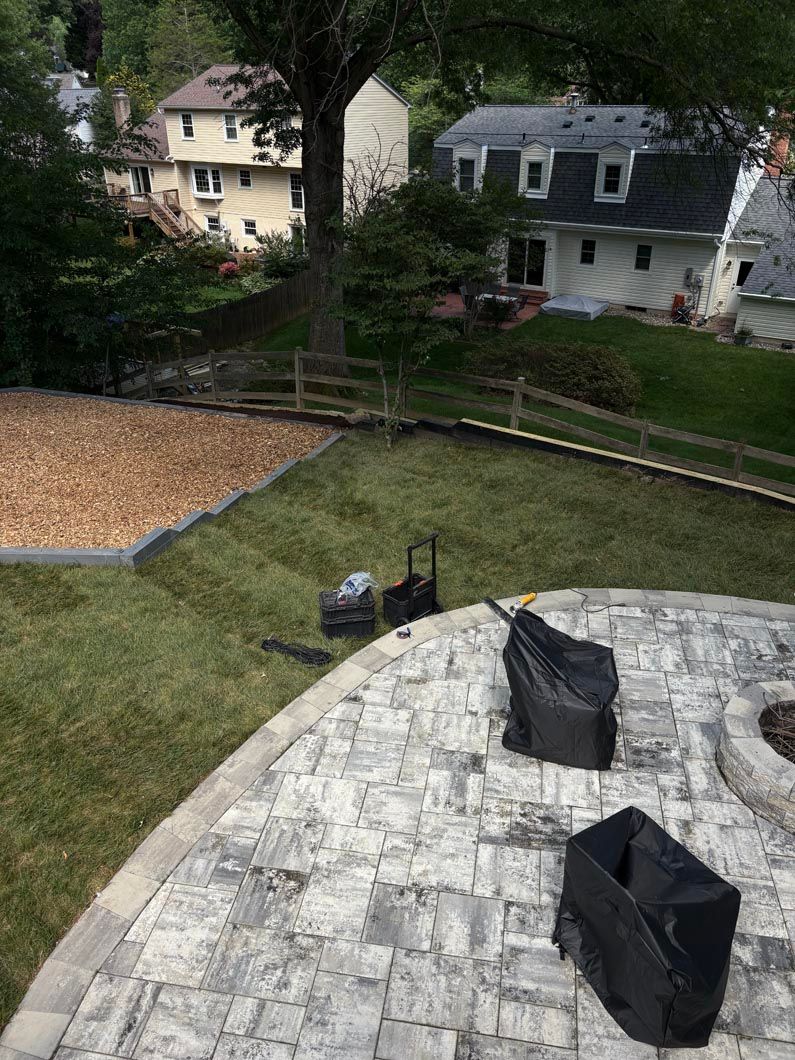 View from a rooftop deck overlooking a sloped backyard, neighboring houses, and trees.