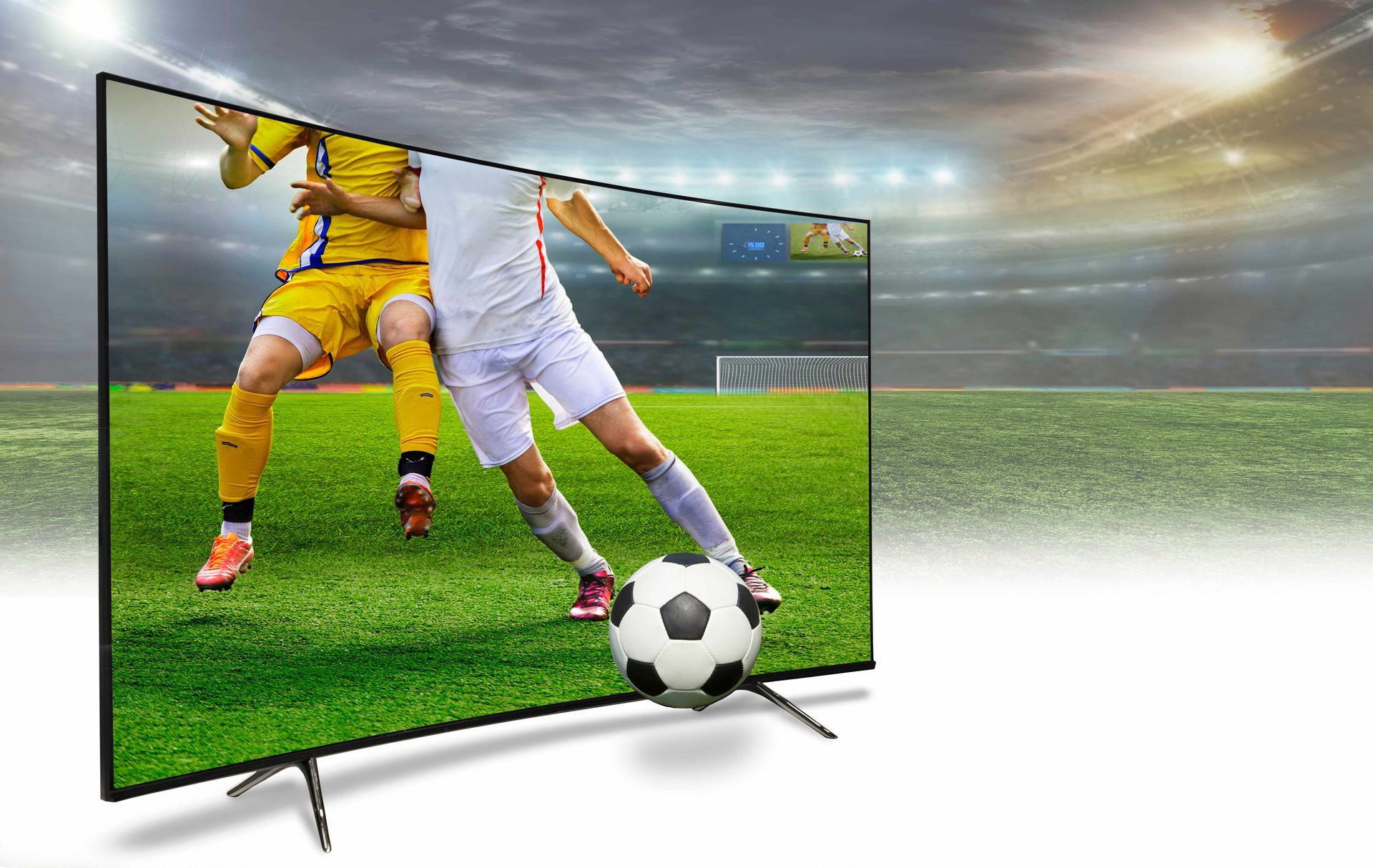 Soccer game on a large TV screen: players in action on green field, stadium background.