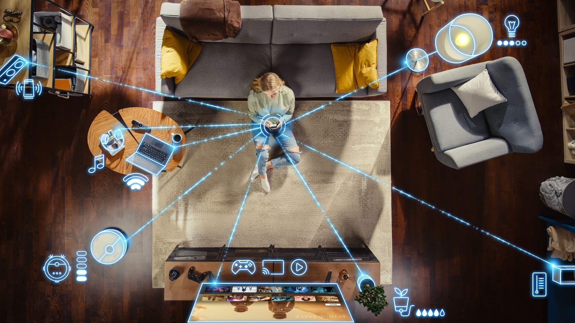 Overhead view of a woman in a living room, using a tablet controlling smart home devices linked by blue lines.
