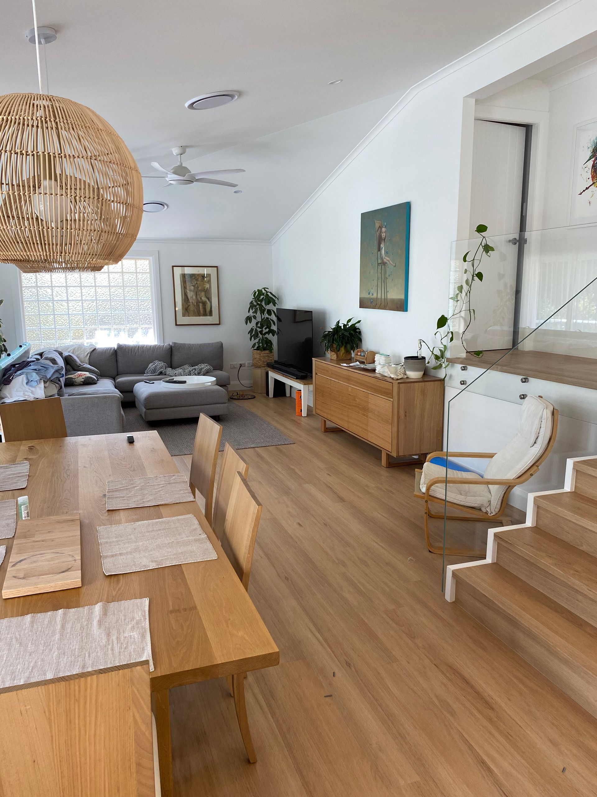Light Wood Floor, Sheer White Curtains, and a Small Wooden Stool With White Legs Sit in Front of a Window — My Timber Flooring Blinds & Shutters in Erina, NSW