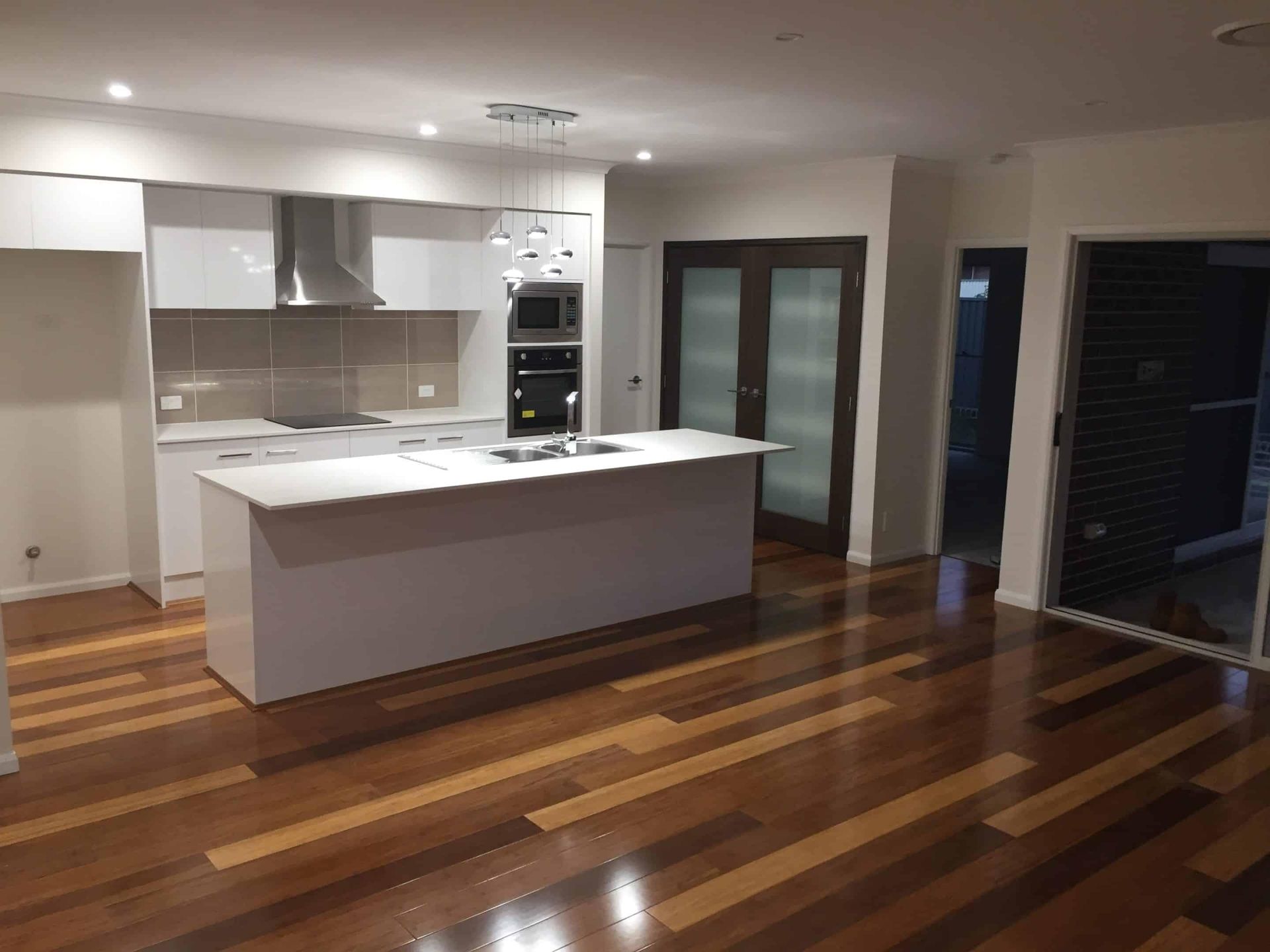 Modern Kitchen with White Cabinets, Island, Stainless Steel Appliances — My Timber Flooring Blinds & Shutters in Erina, NSW