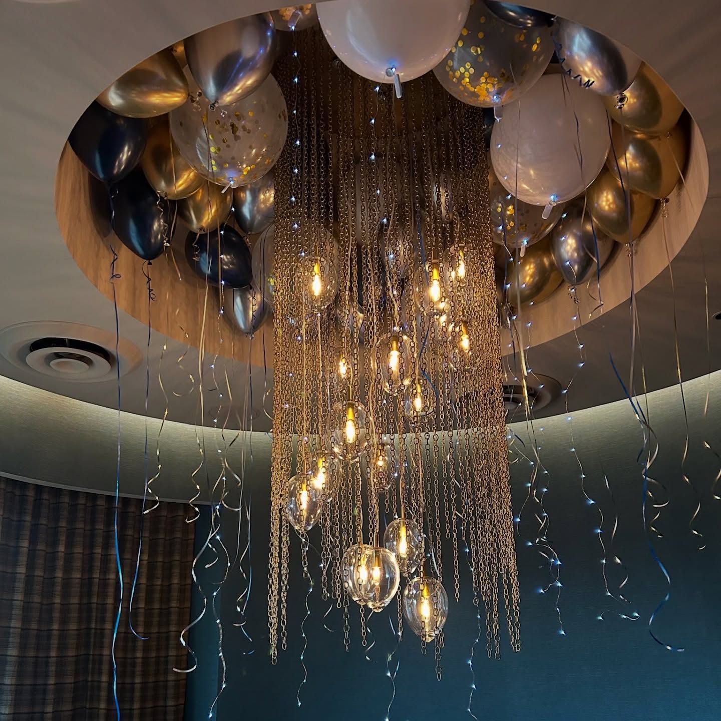 A decorative chandelier adorned with balloons in a celebration setting.