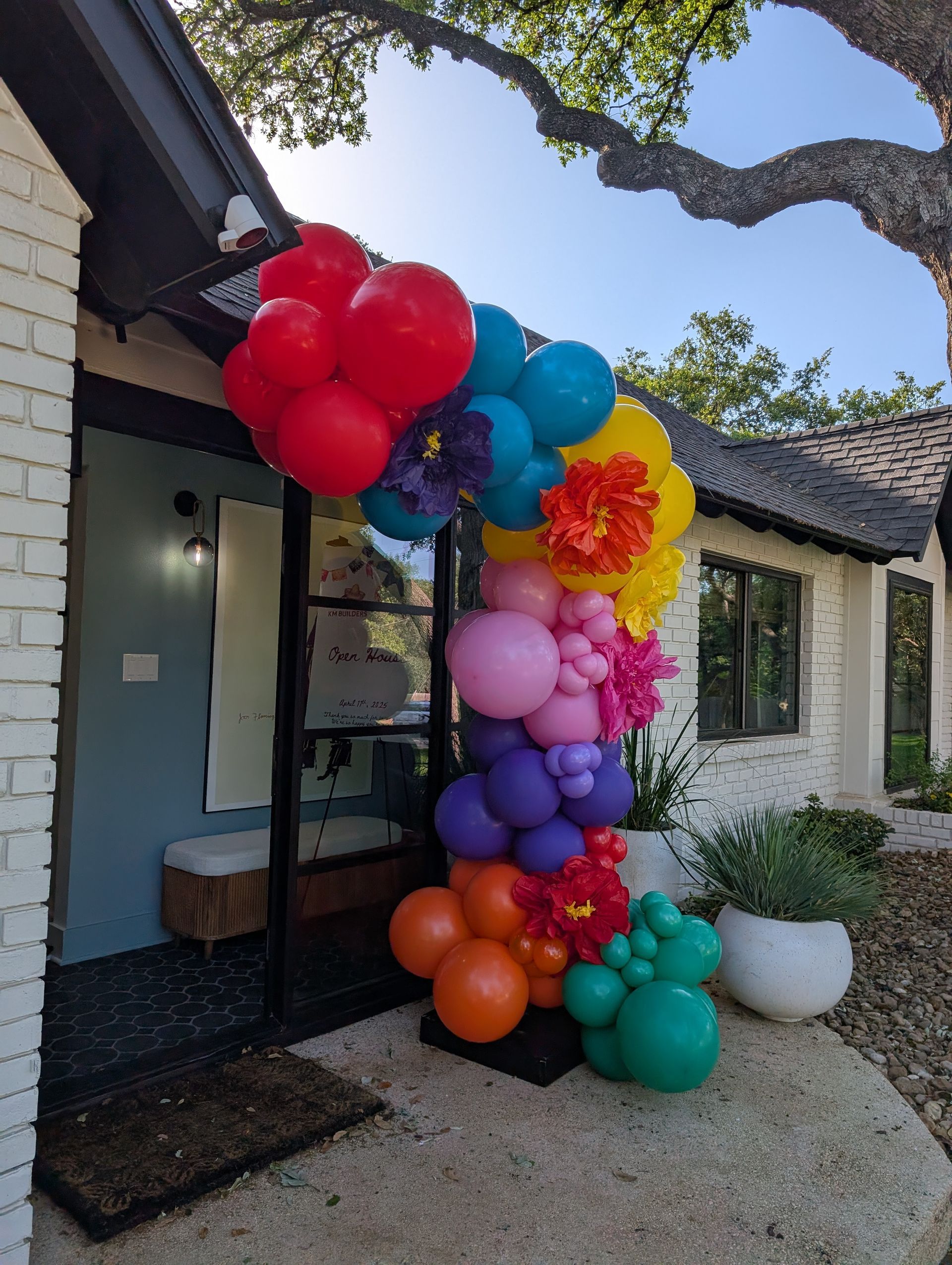 Colorful balloon arch decorates a doorway. Rainbow colors: red, orange, pink, purple, blue, green, yellow.
