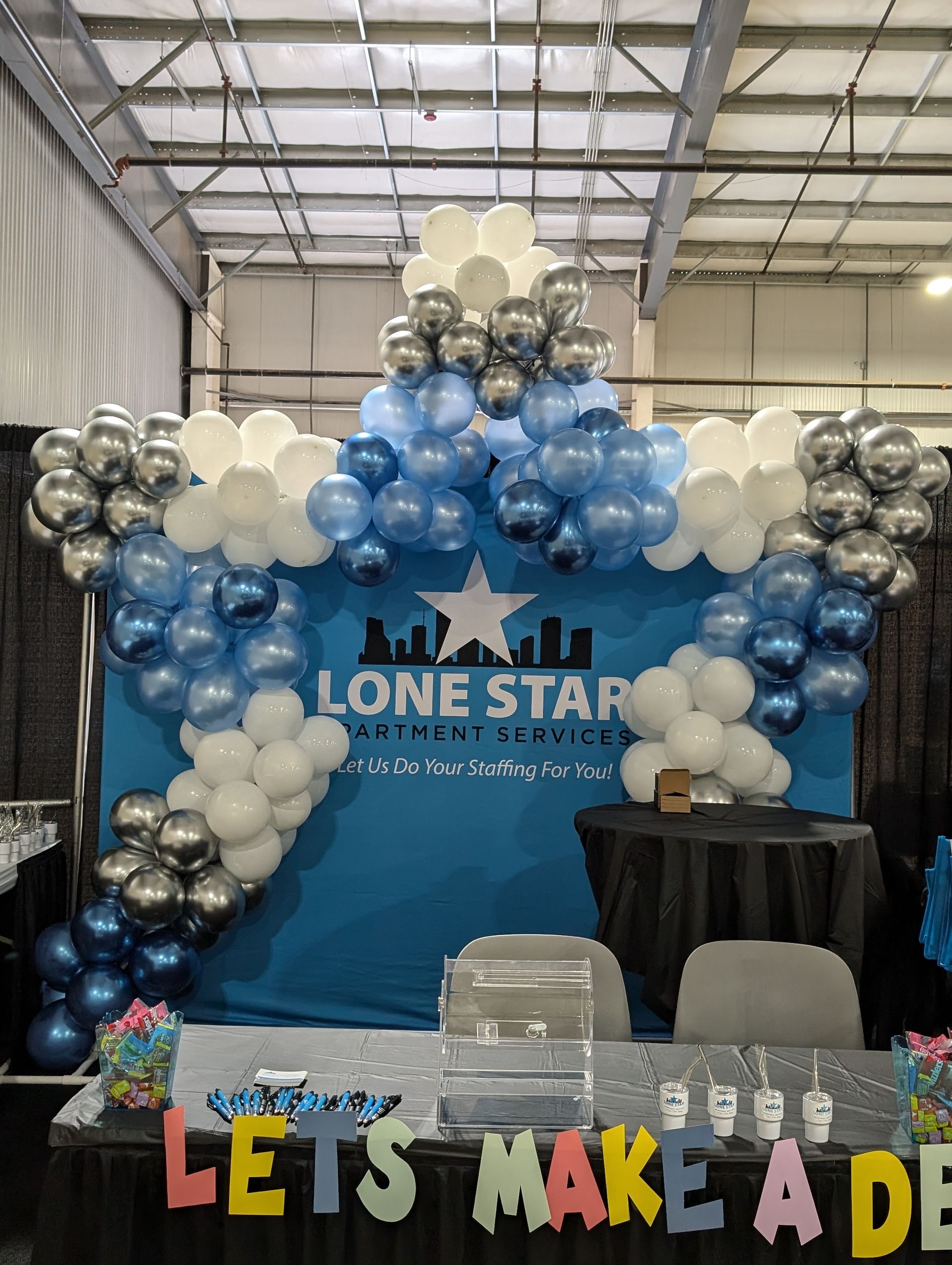 A Lone Star booth with blue & white balloons, star design, &