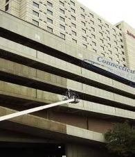 High-rise building façade with “Commercial” sign and a crane arm reaching toward the exterior.