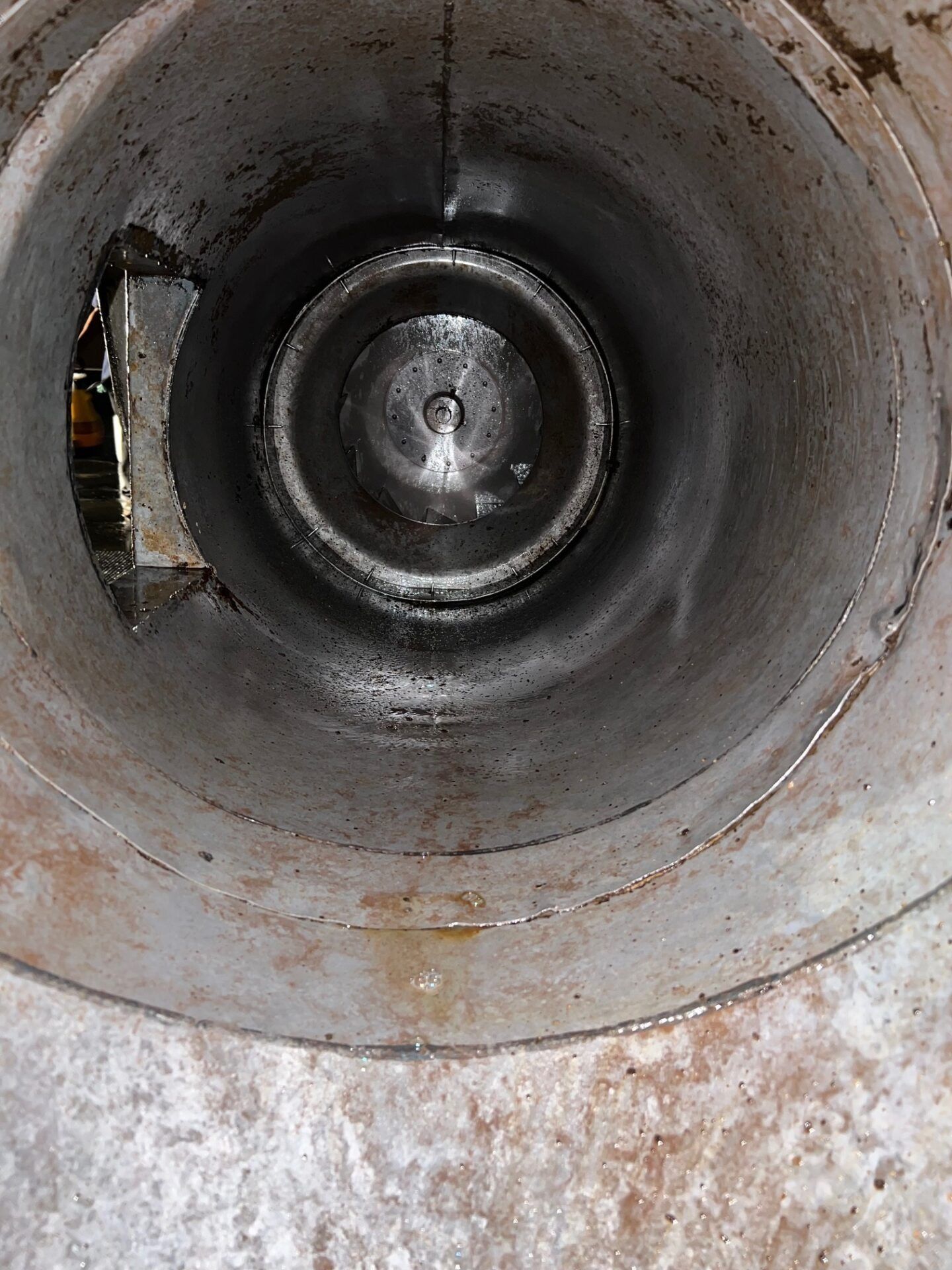 Close-up of a dirty metal pipe interior with rust and grime buildup.