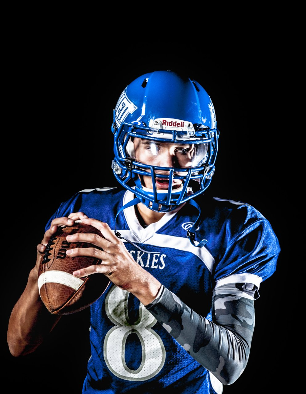 Young male in football pads getting to throw a football