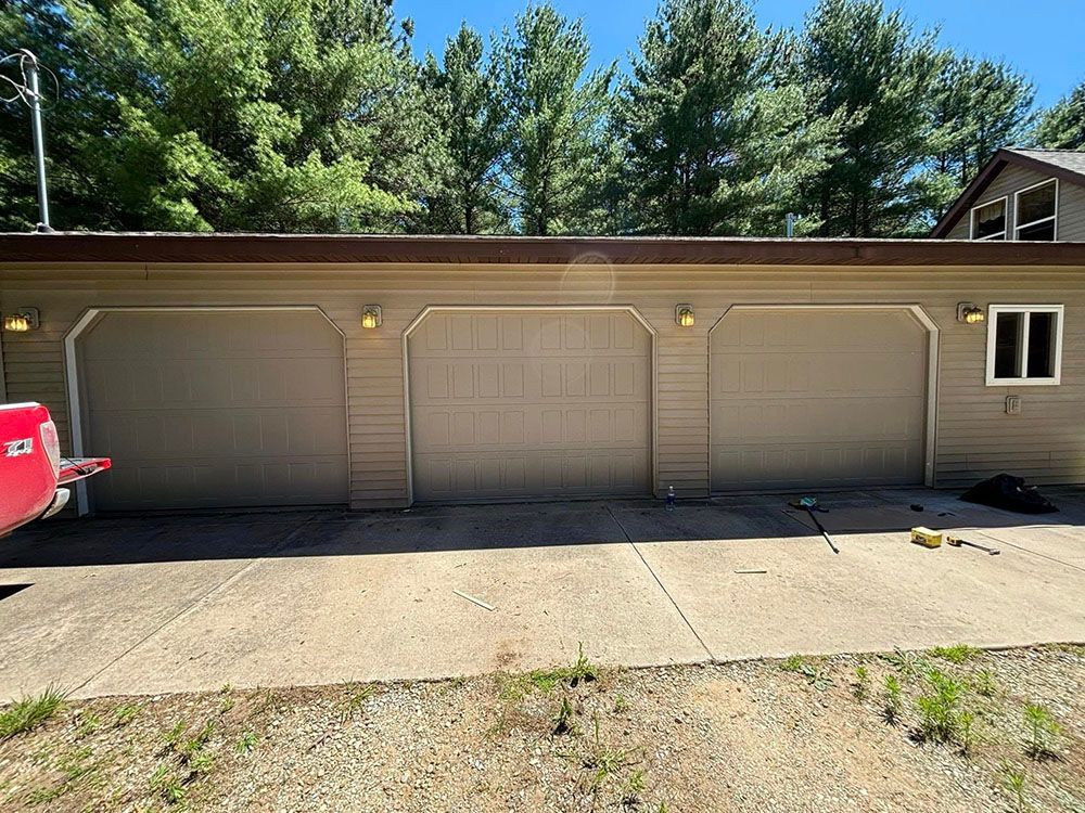 Three-car beige garage with driveway