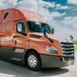 An orange trailer under a sunny blue sky with white clouds in the background An orange trailer under a sunny blue sky with white clouds in the background