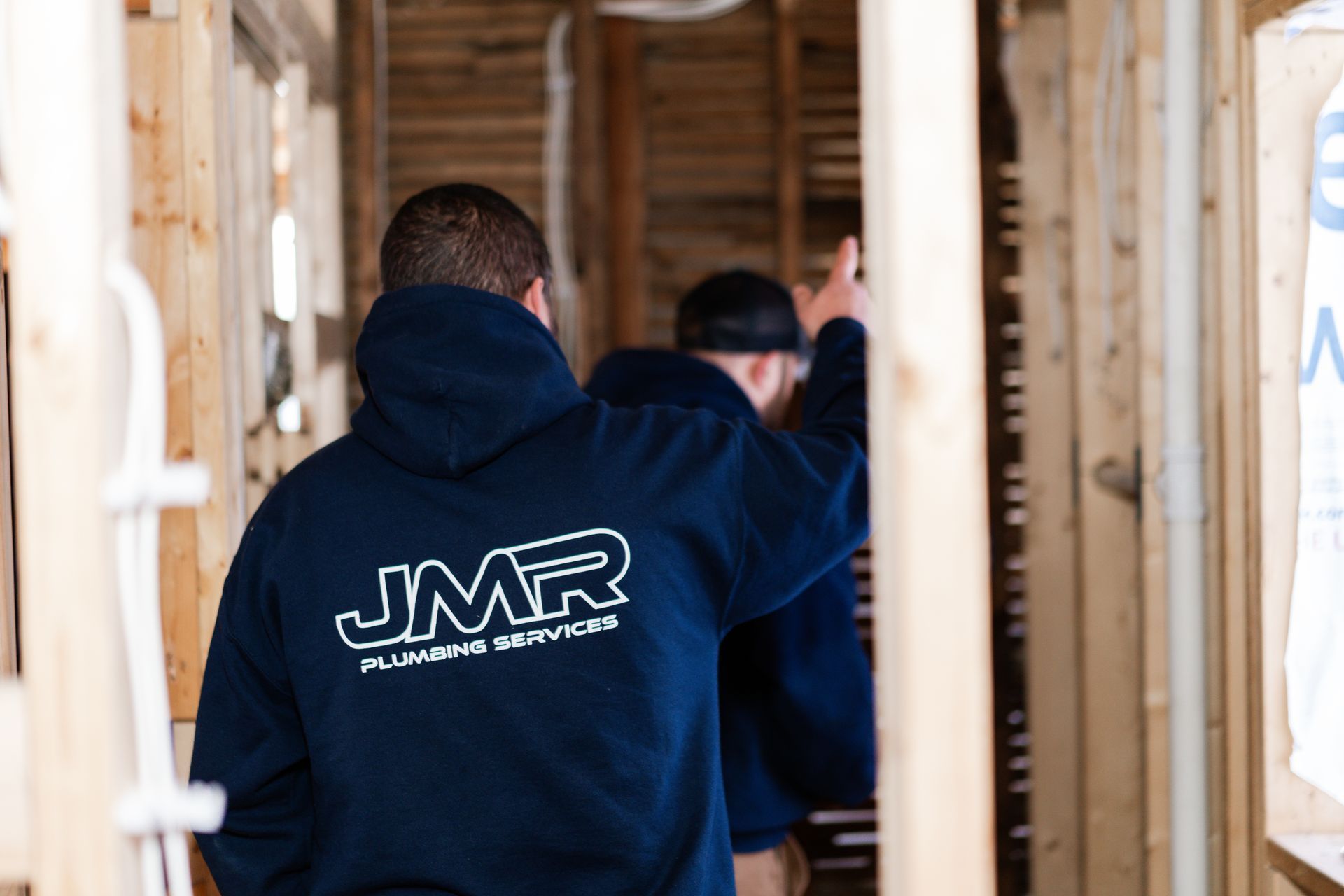 Two people wearing navy hoodies with 