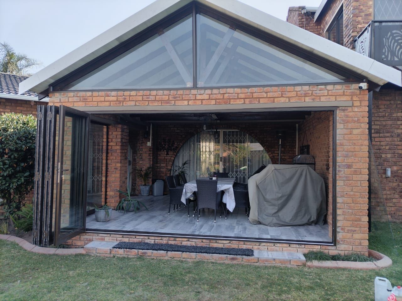 Before-and-after view of a brick house exterior with replaced windows and dark trim