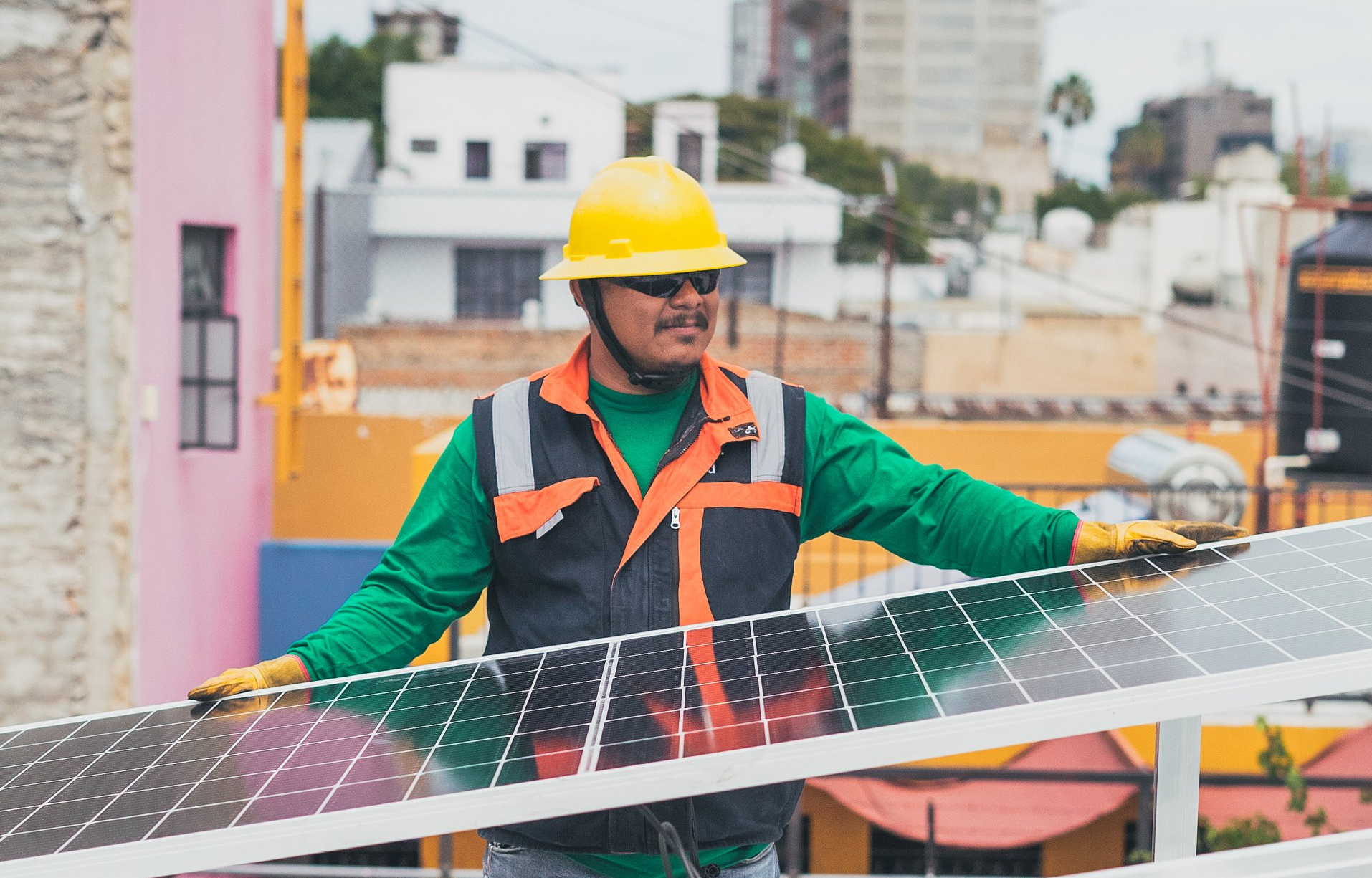 electrician installing solar panels on top of a industrial factory