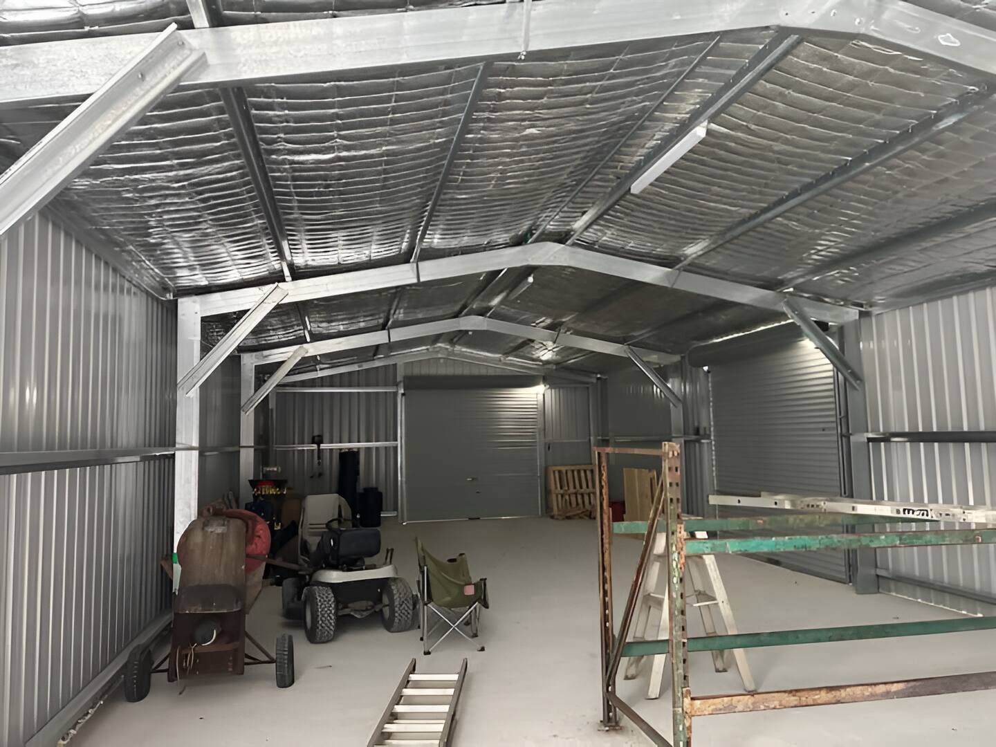 A Shed With A Ladder And A Wheelbarrow Inside Of It — Mbah Metal Roofing In Murwillumbah, NSW