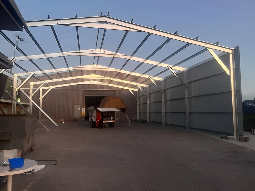 A Warehouse With A Roof That Is Being Built  — Mbah Metal Roofing In Murwillumbah, NSW