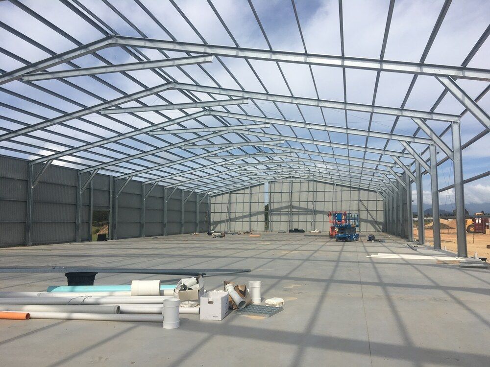 A Large Metal Structure Is Being Built On A Sunny Day — Mbah Metal Roofing In Murwillumbah, NSW