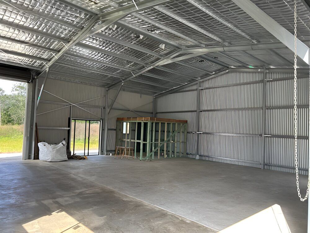 A Large Warehouse With A Concrete Floor And A Metal Roof — Mbah Metal Roofing In Murwillumbah, NSW