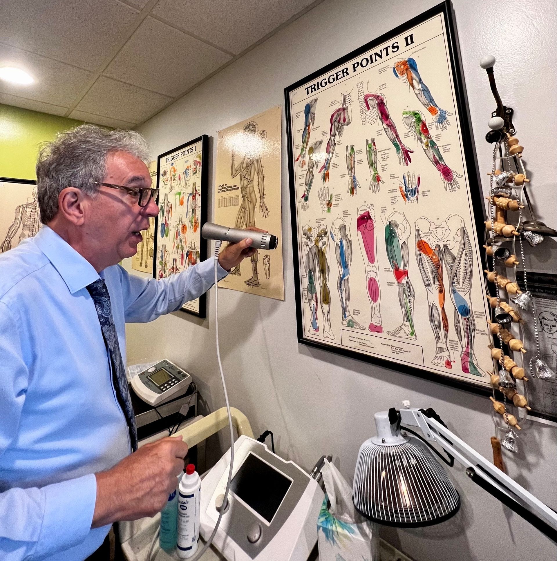 A professional in a blue shirt holds a medical tool toward a