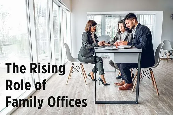 Three people reviewing documents in a modern office with large windows. Text reads: