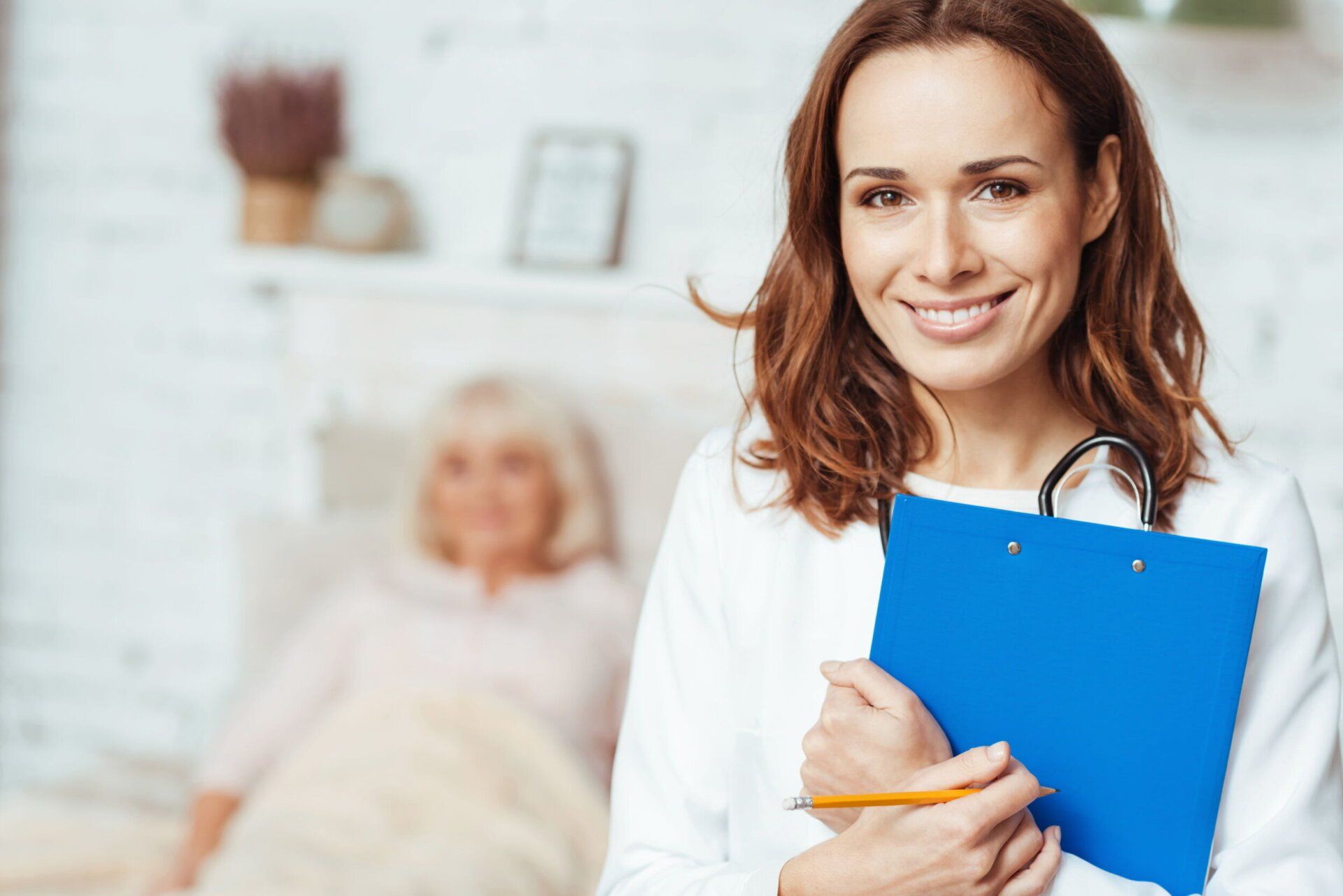 A female doctor is smiling while holding a clipboard and a stethoscope.