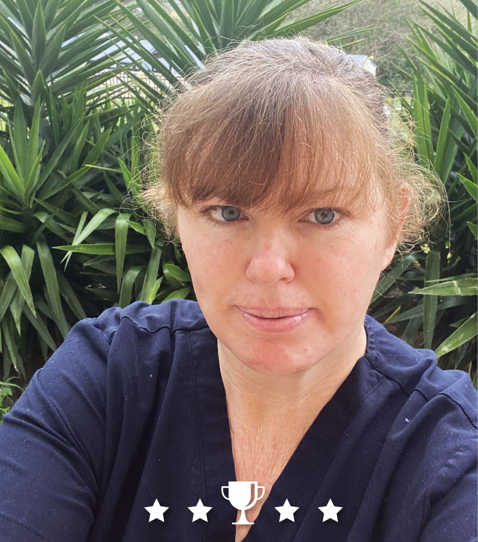 A woman is taking a selfie with a trophy in the background