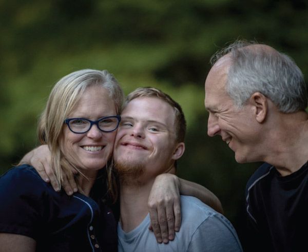 Family with a disabled member hugging.