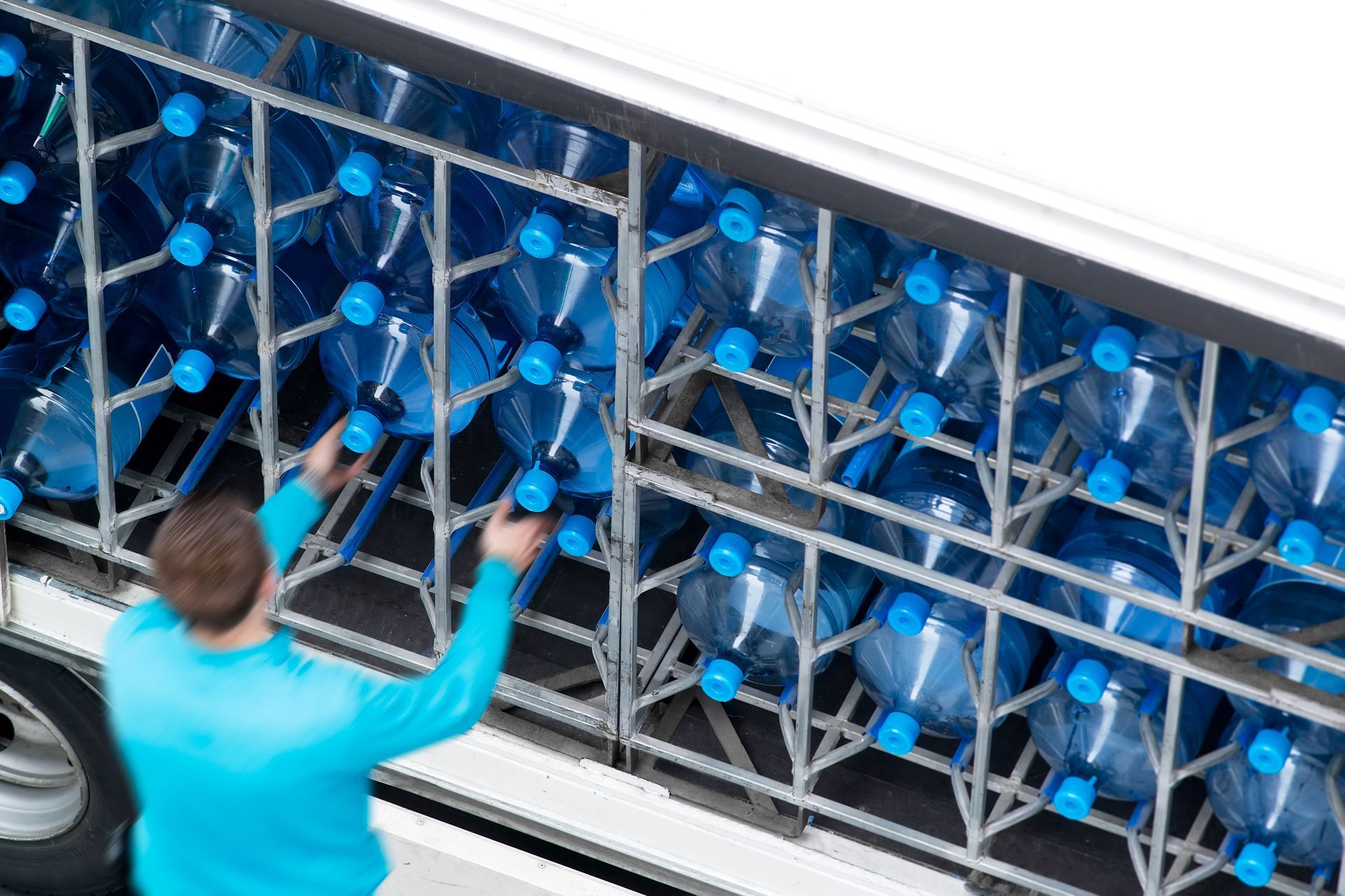water delivery courier working in motion blur with great plastic bottles in van