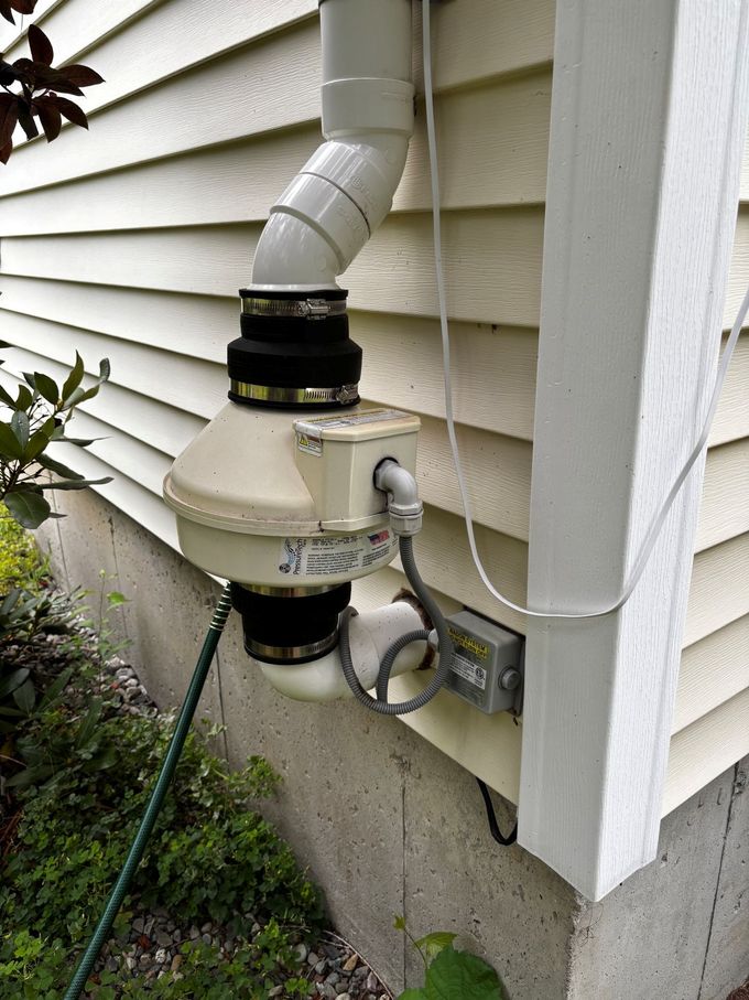 Electric meter and service conduit mounted on the exterior siding of a house.