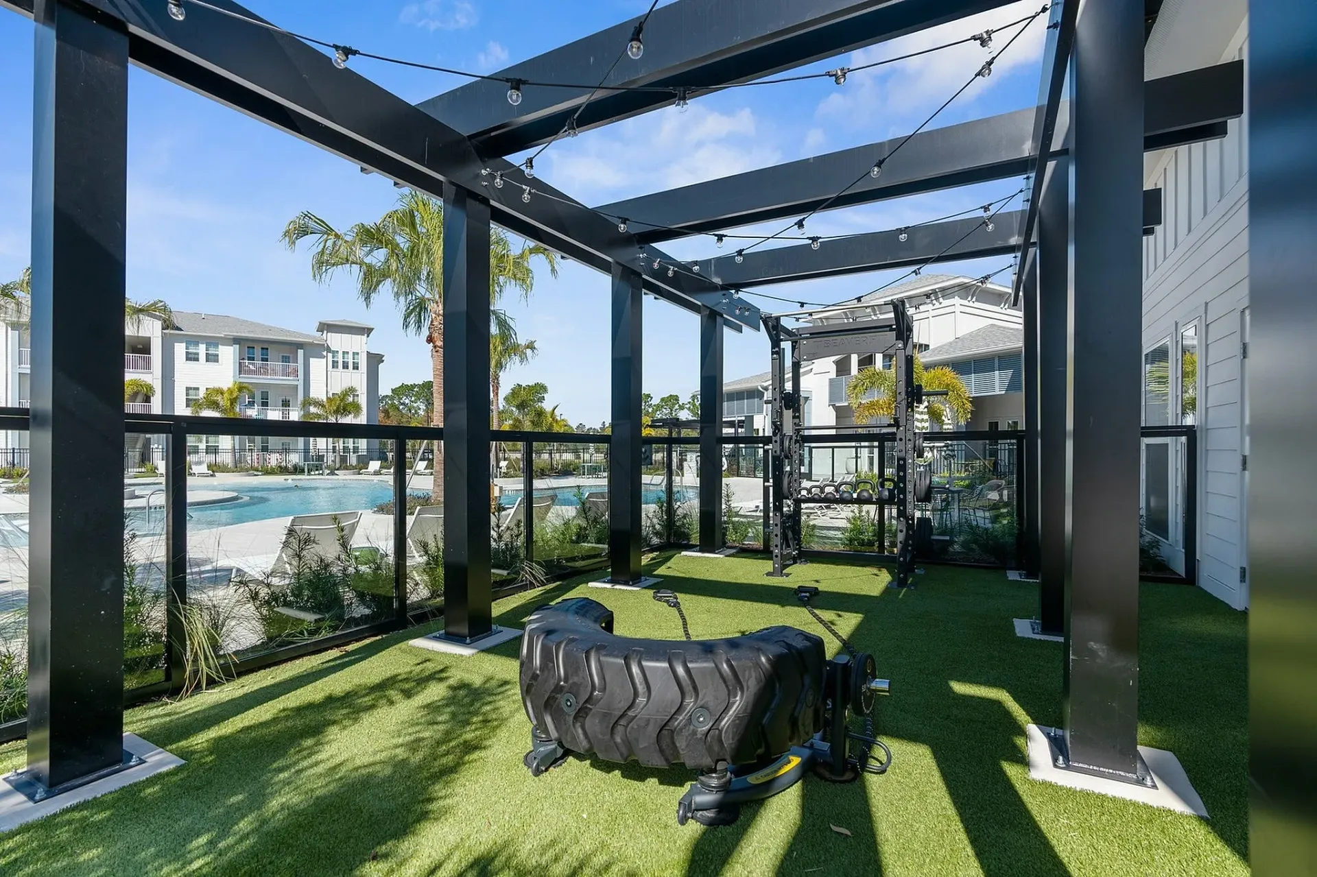 Elevate your workout in this stunning outdoor fitness space with pool views.