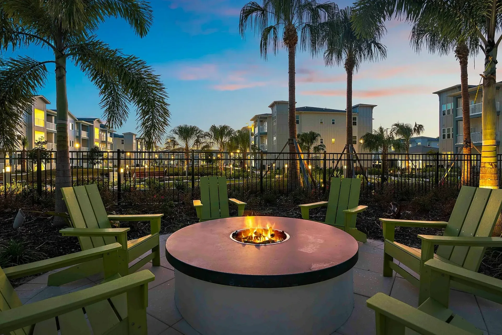 Relax in style with this luxurious outdoor fire pit setting, offering a perfect blend of comfort and tropical elegance.