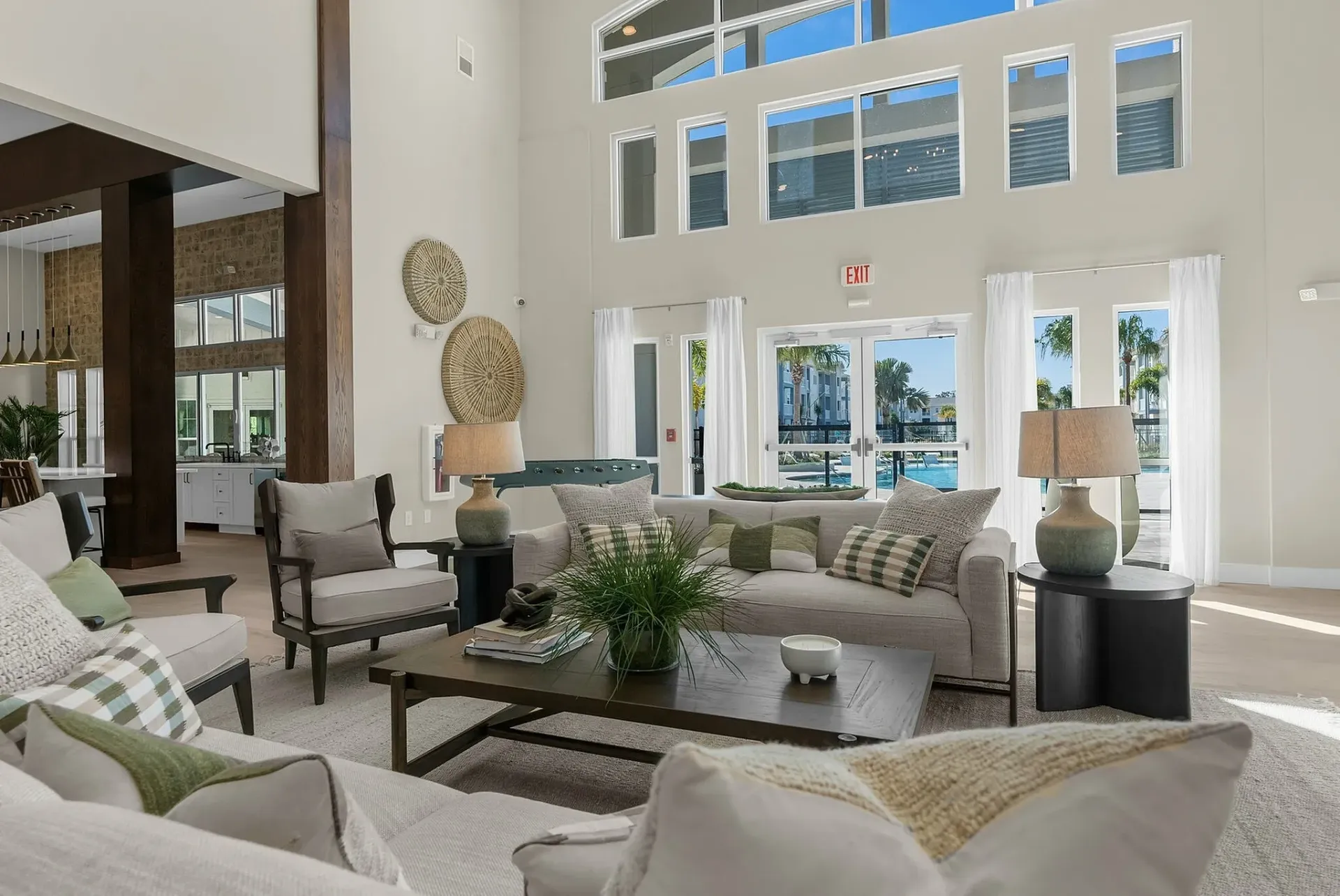 Experience comfort and style in this spacious living room featuring modern decor and panoramic pool views.