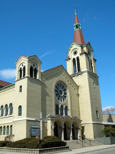 Light-yellow church with two towers, a steeple, and a blue sky. St. John Church 2005