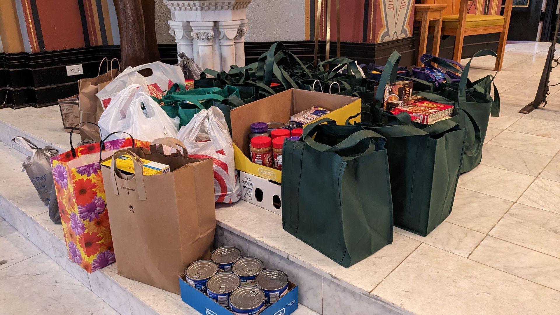 Food donations: bags and boxes of groceries on steps, likely for a food bank or similar.