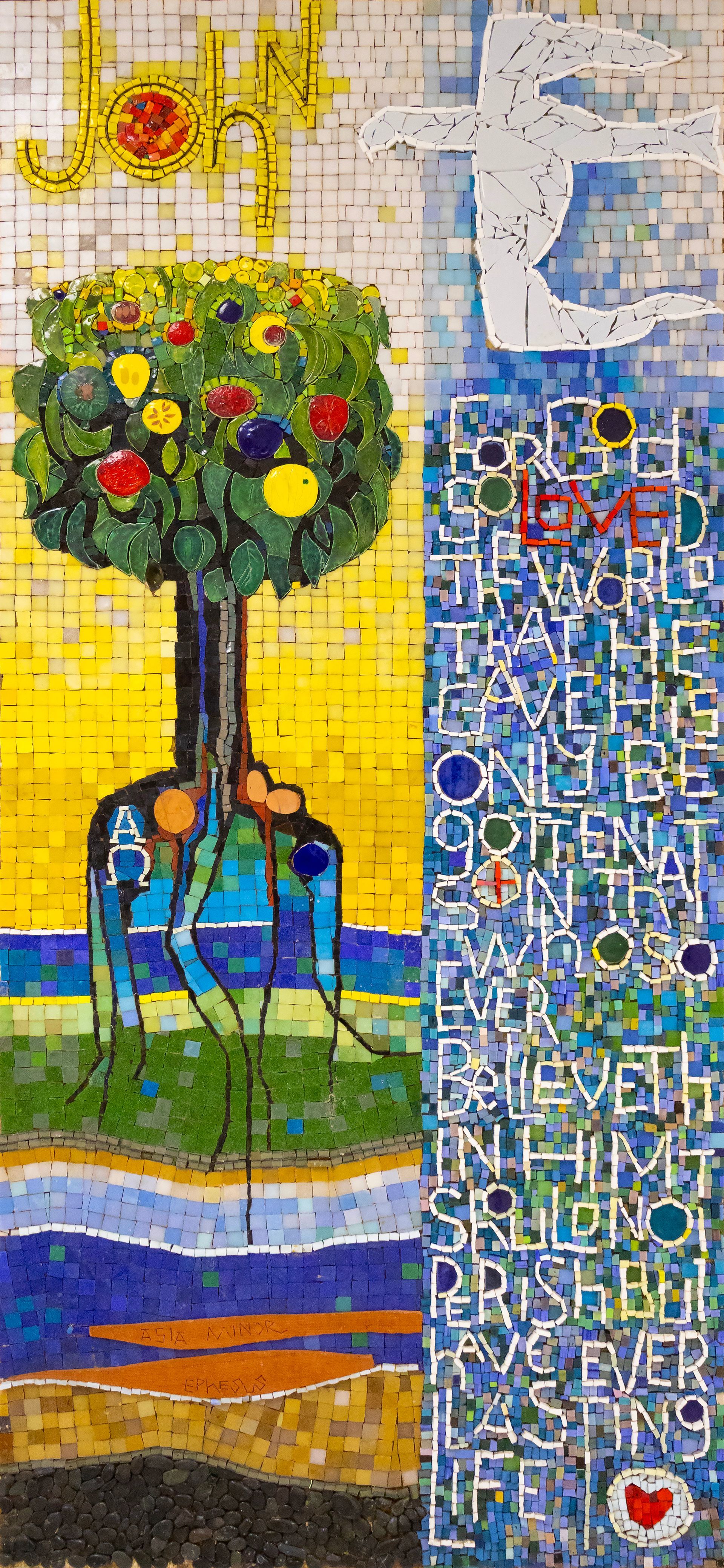Mosaic art of a tree with fruit, text, and a heart. The word